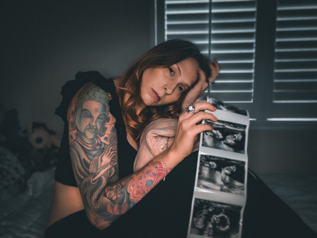 Cydney holding her ultrasound photos, looking sad. Demonstration of what Prenatal Depression is like.